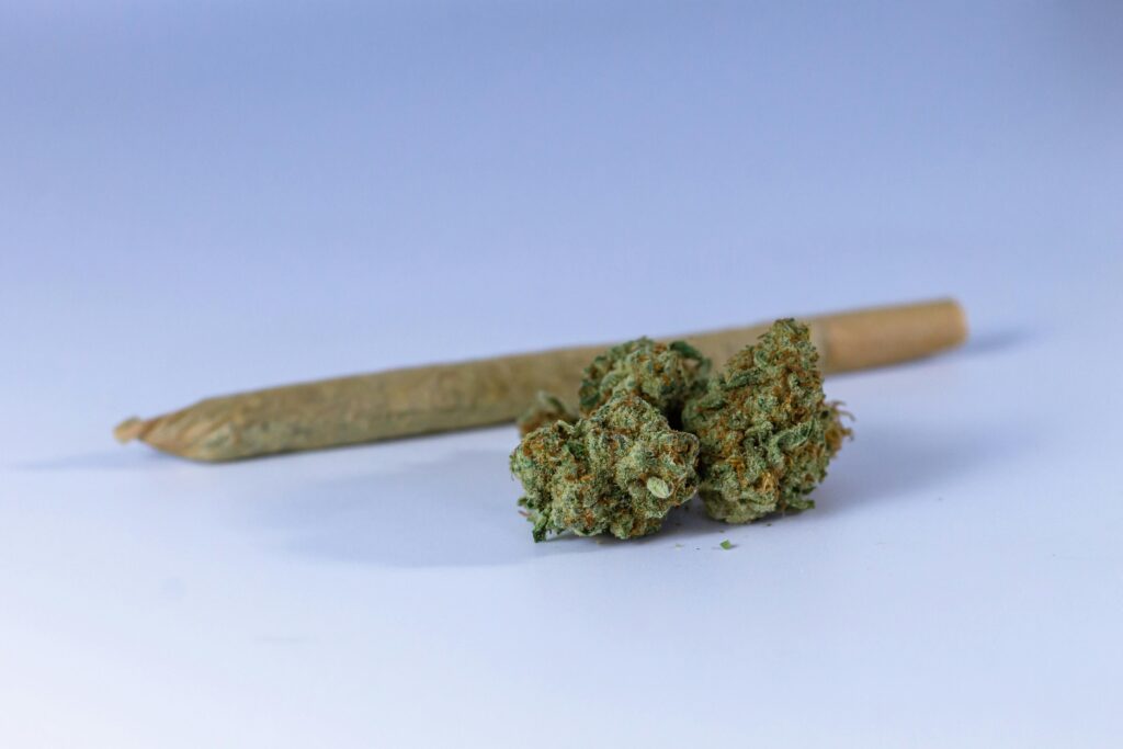 A close-up image of a cannabis joint and buds set against a neutral background, perfect for illustrating marijuana-related topics.